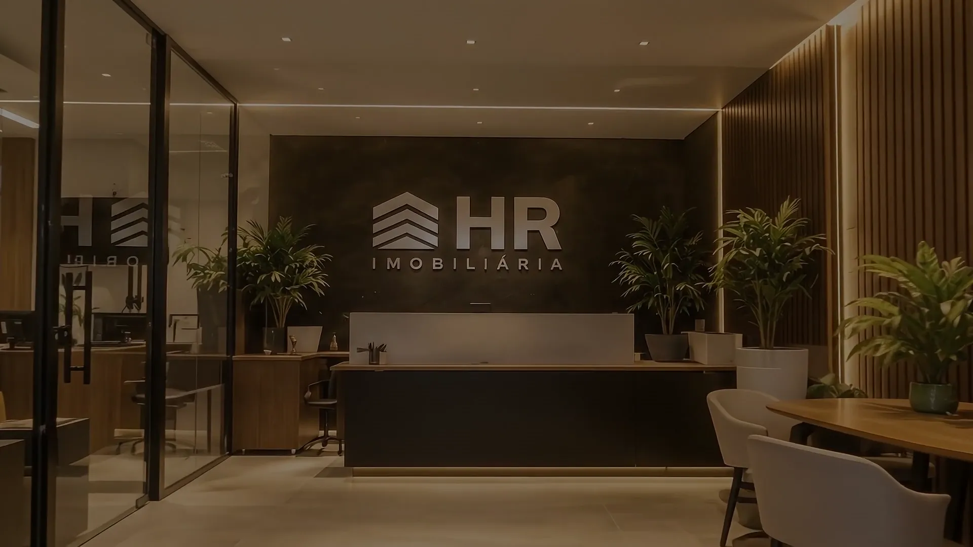Recepção da HR Imobiliária em Caiobá, com painel de madeira e o logo HR